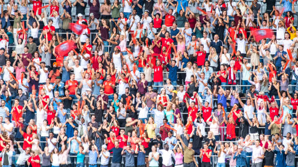 istock Group of spectators cheering in stadium 1129607836