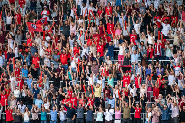 istock Group of spectators cheering in stadium 1129607843