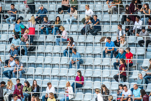 Group of spectators using smart phone in stadium.