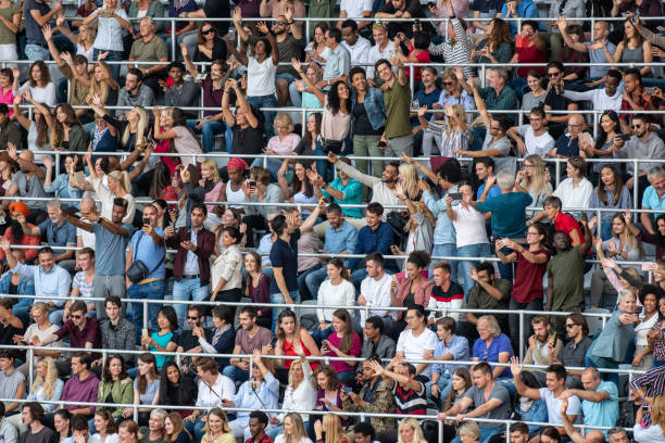 istock Group of spectators cheering in stadium 1129607870