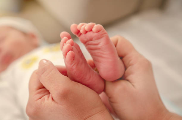istock Baby feet in mother hands 1129608125