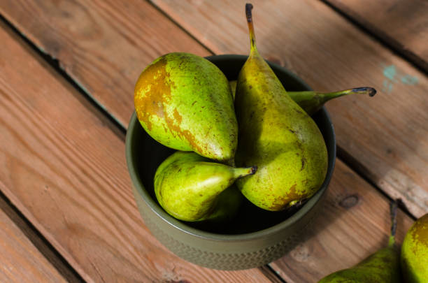 istock Fresh juicy Pears Conference in a bowl on a wooden rustic background 1129608338