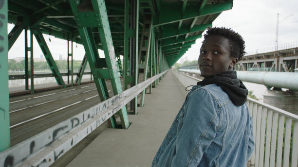 istock Loneliness young man walking under bridge. Looking away 1129608951