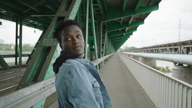 istock Loneliness young man walking under bridge. Looking away 1129609111