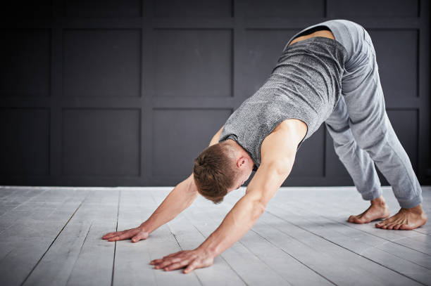 Young strong man practices yoga at the yoga studio