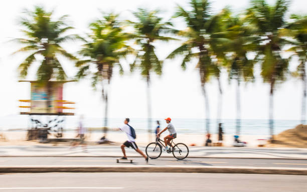 radfahrer und skater an der copacabana, rio de janeiro - brazil bicycle rio de janeiro outdoors stock-fotos und bilder