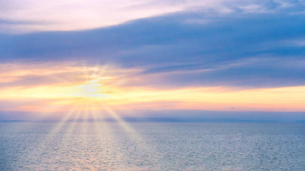 istock Dreamy Soft Sunrise over the Sea with Sun and Sun Rays 1129611685