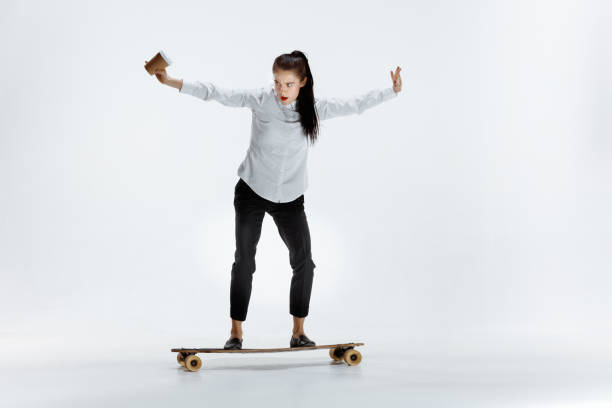 istock businesswoman riding skate on white background 1129612222