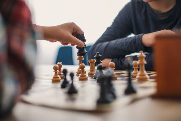 istock Two boys playing a game of chess in chess school 1129613254