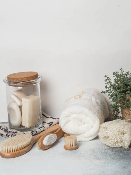istock Zero waste concept. Eco-friendly bath set. Brushes, soap in jar, towel, pumice and bast and plant in wood flowerpot. Copy space 1129613359