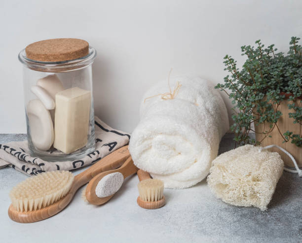 Zero waste concept. Eco-friendly bath set. Brushes, soap in jar, towel, pumice and bast and plant in wood flowerpot. Copy space stock photo