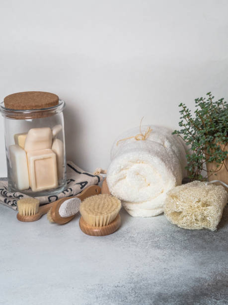 istock Zero waste concept. Eco-friendly bath set. Brushes, soap in jar, towel, pumice and bast and plant in wood flowerpot. Copy space 1129613373