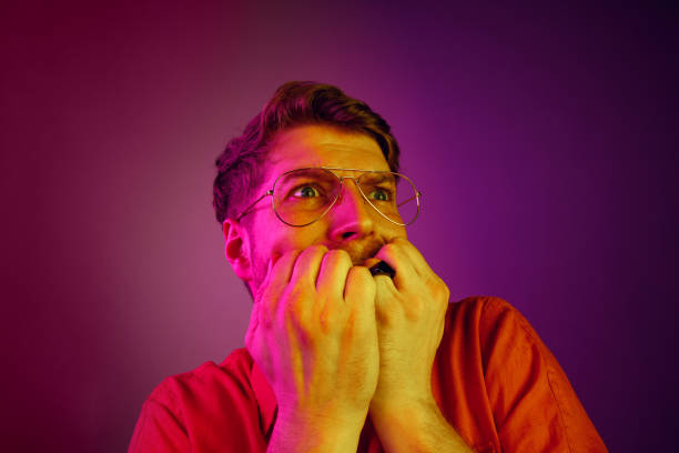 istock Portrait of the scared man on pink 1129613528