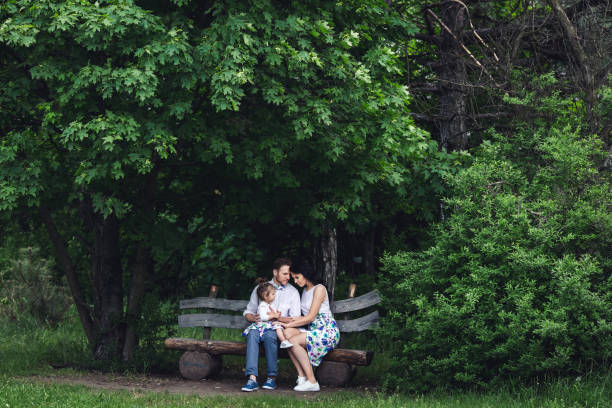istock friendly happy family resting on a wooden bench under the maple 1129614767