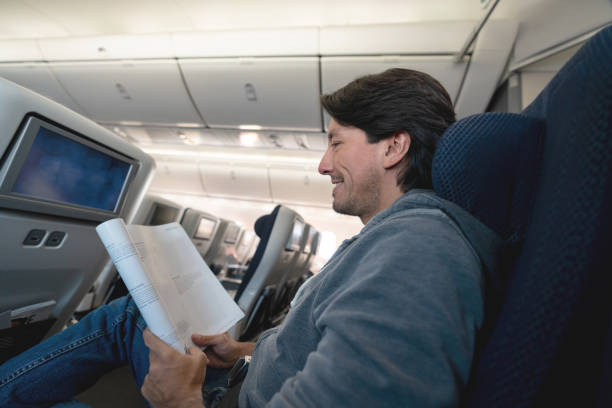 istock Man traveling by plane and reading a magazine 1129618434