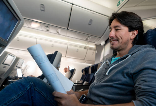 istock Man traveling by plane and reading a travel magazine 1129618436