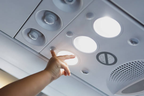 istock child hand pointing to the light lamp in airplane cabin 1129620573