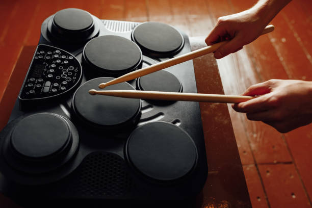 istock hands playing on portable electronic drums, brown background 1129624570