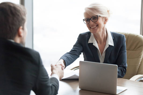 istock Friendly hr manager handshaking applicant hiring candidate at job interview 1129629331