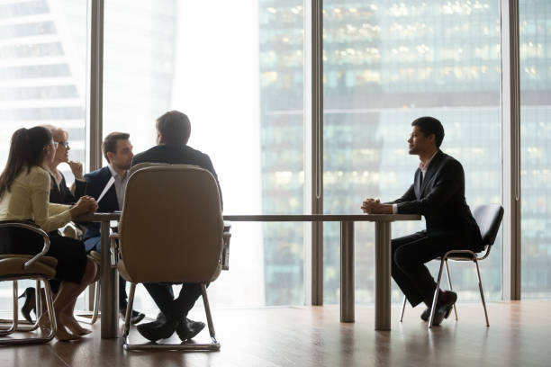 istock Hr team interviewing african candidate sitting at table in office 1129629334