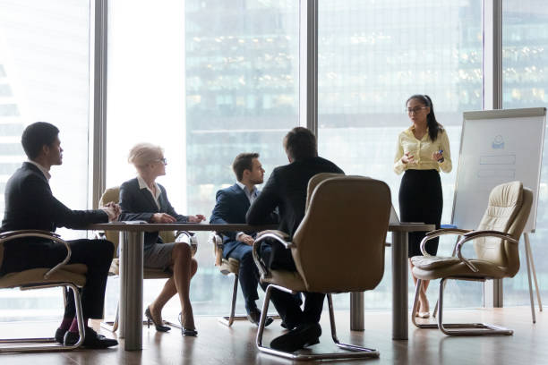 istock Asian coach giving business presentation at board multi-ethnic team meeting 1129629359