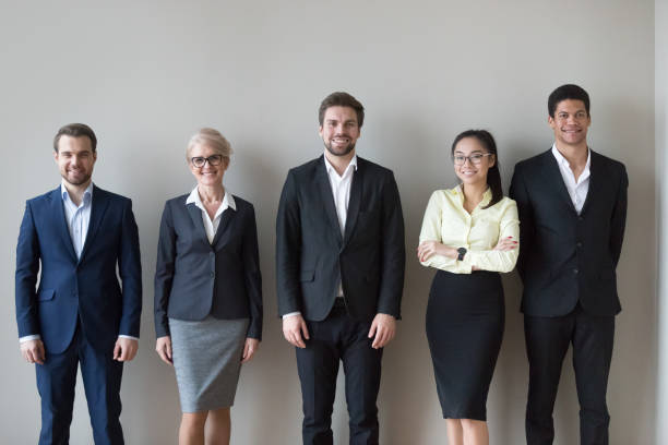 istock Happy diverse executives team standing near wall headshot portrait 1129629370