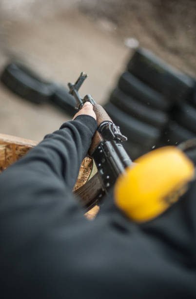 istock Combat riffle machine gun shooting from behind cover or barricade 1129632148