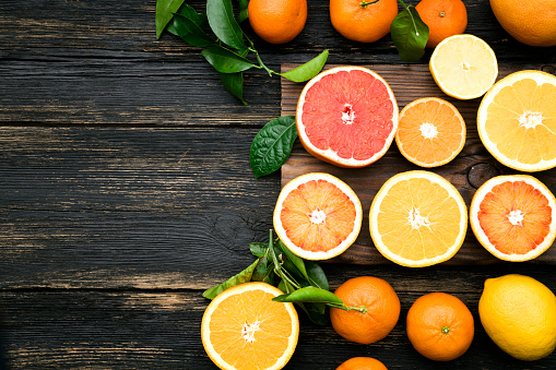 citrus fruits on wooden table with space on text