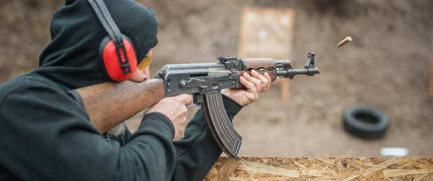 istock Combat riffle machine gun shooting from behind cover or barricade 1129632281
