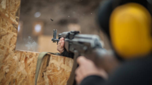 istock Combat riffle machine gun shooting from behind cover or barricade 1129632337