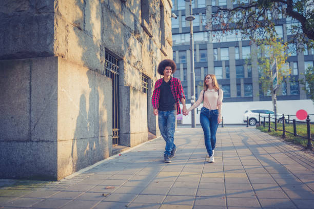 istock A young loving student couple, hugging and walking down the street. 1129635592