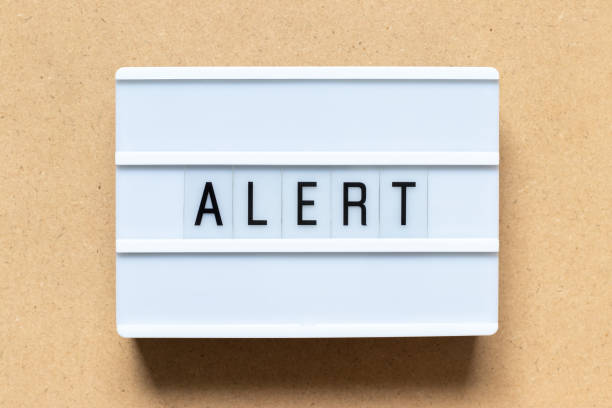 istock White lightbox with word alert on wood background 1129637411