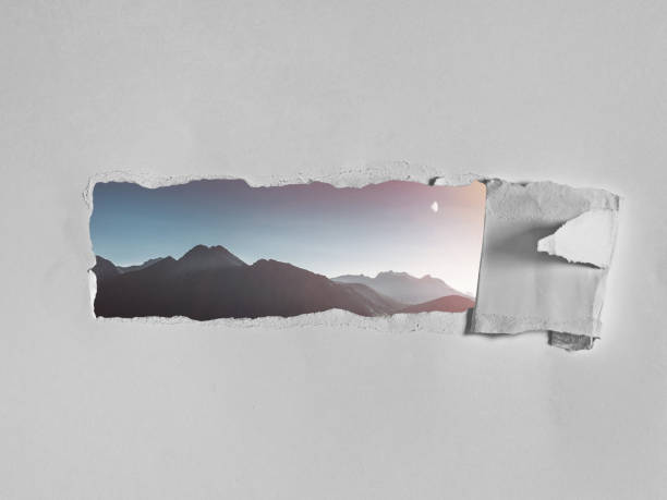 Torn hole in the white paper with a picturesque view of mountains. Creative concept of seeing the world, traveling, open your mind stock photo