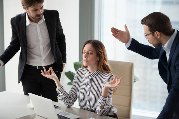 istock Mindful calm woman boss meditating at work ignoring angry colleagues 1129638569