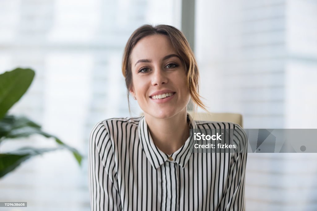 Smiling businesswoman looking at camera webcam make conference business call Smiling businesswoman looking at camera webcam make conference business call, recording video blog, talking with client, distance job interview, e-coaching, online training concept, headshot portrait Women Stock Photo