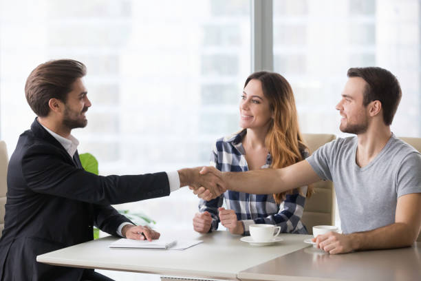 istock Happy clients couple handshake lawyer thanking for help 1129638635