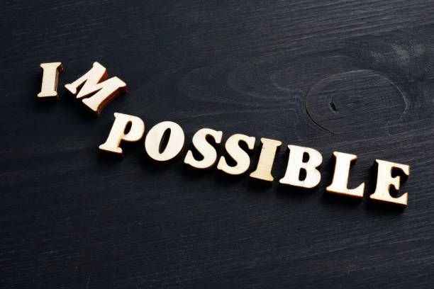 istock Word possible changed to impossible. Letters on the dark wood. 1129640337