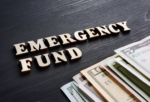 Emergency fund from wooden letters and money.