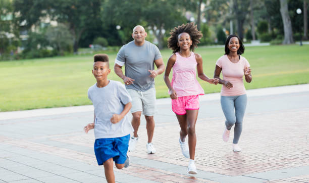 istock Interracial family running in park together 1129640548
