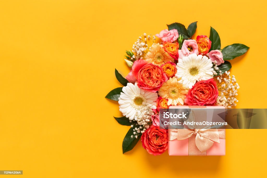 Happy Mother's Day, Women's Day, Valentine's Day or Birthday Pastel Candy Colors Background. Floral flat lay greeting card with beautifuly wrapped present and copy space. Flower Stock Photo