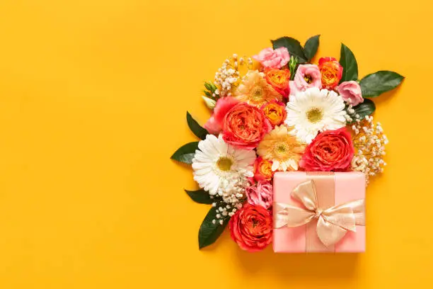 Photo of Happy Mother's Day, Women's Day, Valentine's Day or Birthday Pastel Candy Colors Background. Floral flat lay greeting card with beautifuly wrapped present and copy space.