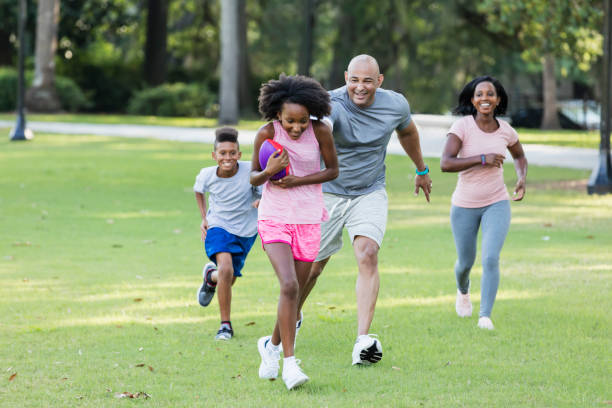 istock Interracial family with two children having fun in park 1129643396