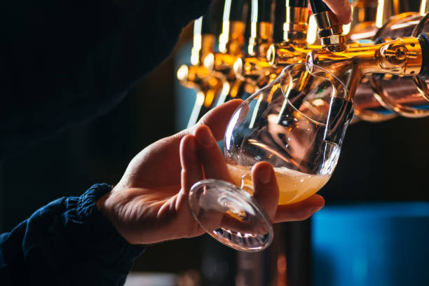 istock Hand of bartender pouring a lager beer in tap 1129643490