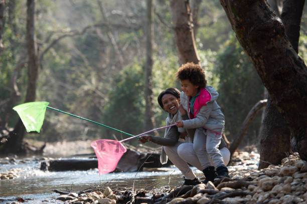 istock Mother and daughter fishing using net. 1129645024