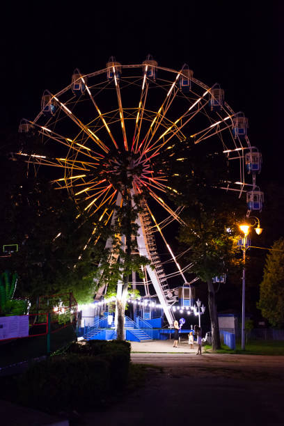 istock glowing Ferris wheel at night in an amusement park 1129645589