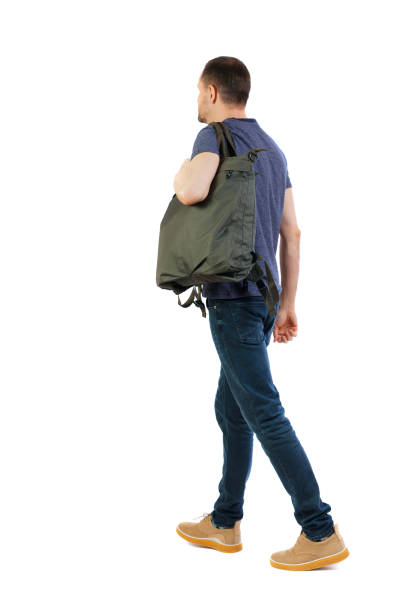 istock back view of walking  man  with green bag. 1129646425