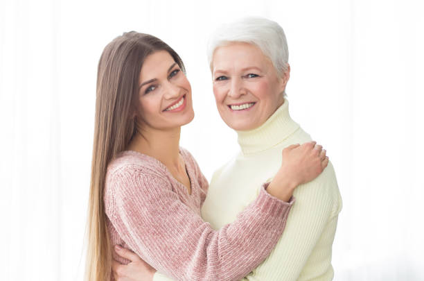 istock Senior mother and daughter embracing and looking at camera 1129646578