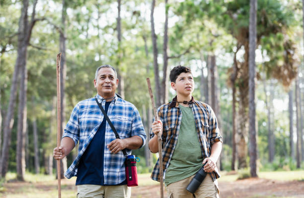 istock Hispanic boy and father hiking in woods 1129646642