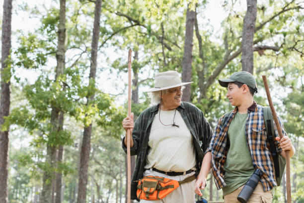 istock Senior Hispanic man and grandson hiking in park 1129648101