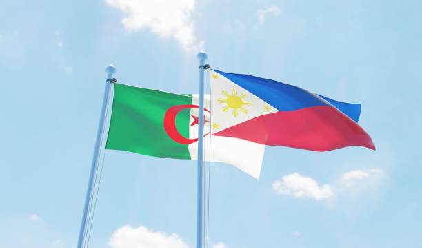 istock Philippines and Algeria, two flags waving against blue sky 1129648445